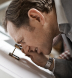 Man looking through magnifying glass